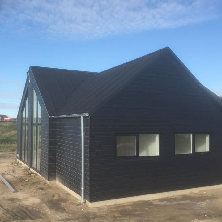 Moderne sort træhus med store vinduer